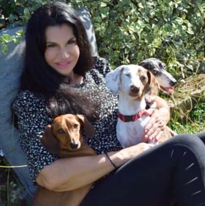 dog-boarding-in-fort-lauderdale Dog sitter is sitting with 3 of her dachshunds.