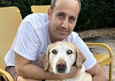 Male pet sitter is holding his golden retriever.