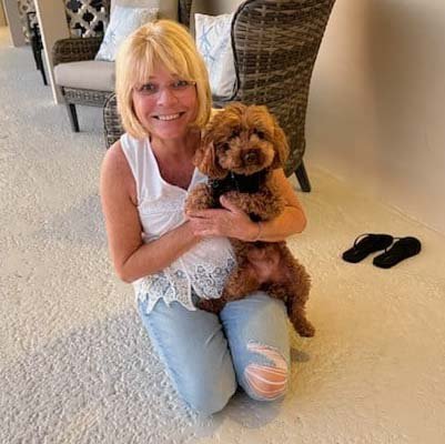 dog-sitter-in-pompano-beach Dog sitter is hugging a dog inside a house.