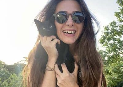 Pet sitter is holding a cute black kitten.