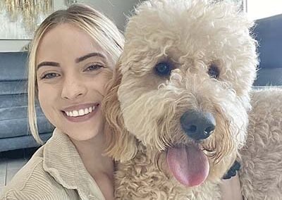 Blond pet sitter with her labradoodle dog.