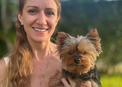 Beautiful pet sitter is holding a little yorki dog in Fort Lauderdale.